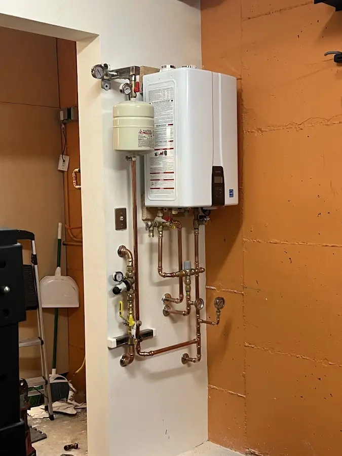 Plumbing technician inspecting water heater connections in Marlton